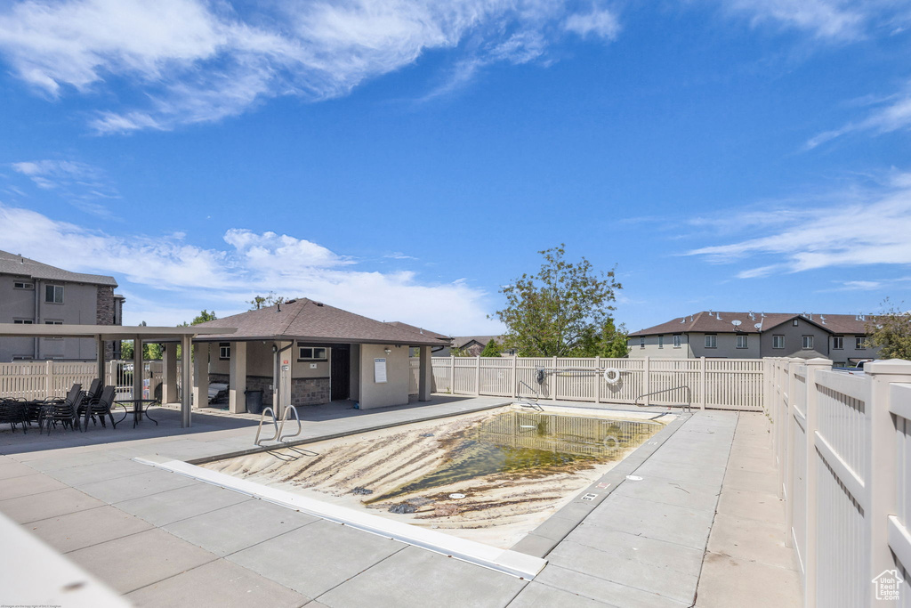 Exterior space with fence, a patio, a community pool, and a residential view