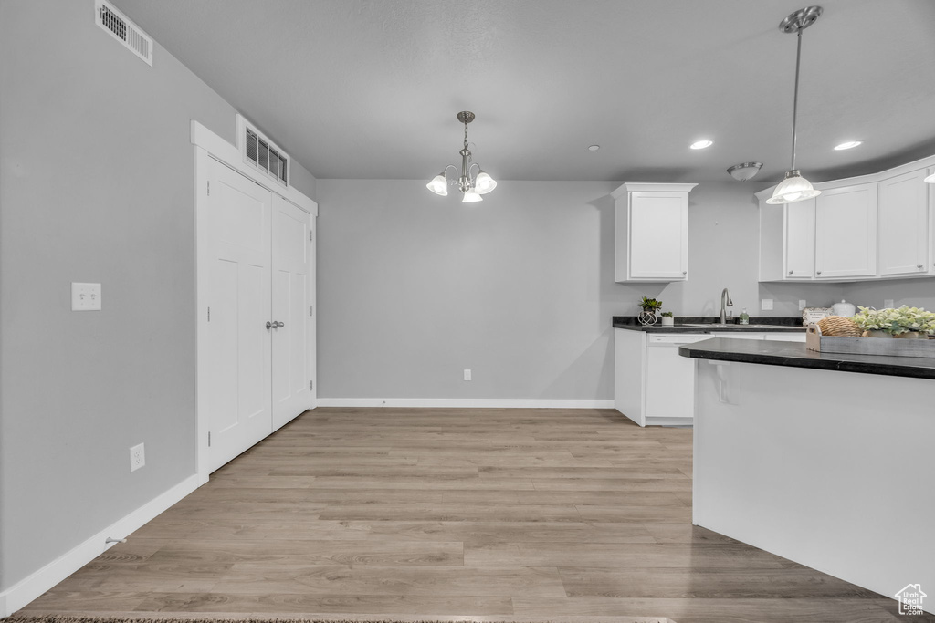 Kitchen with dark countertops, a notable chandelier, white cabinetry, visible vents, and recessed lighting