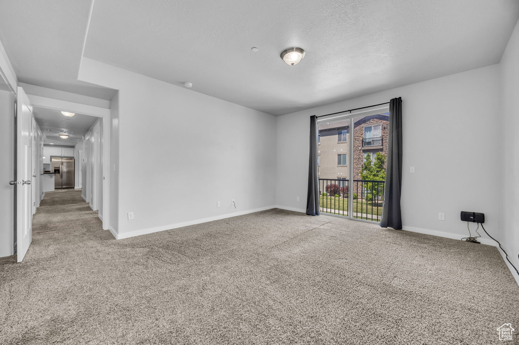 Empty room featuring baseboards and light carpet