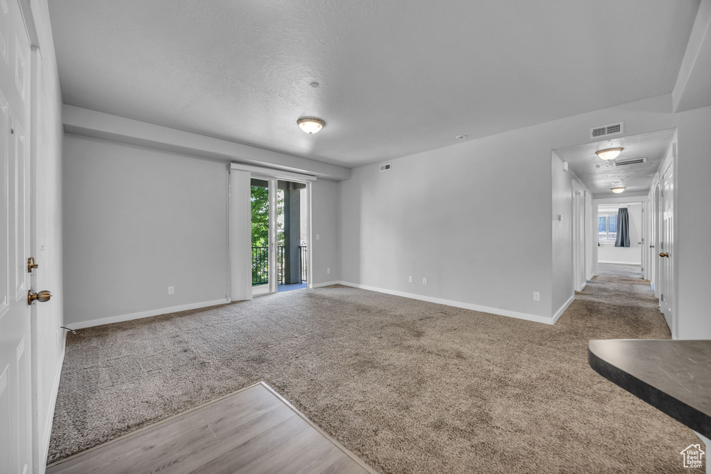 Empty room featuring baseboards, visible vents, and carpet