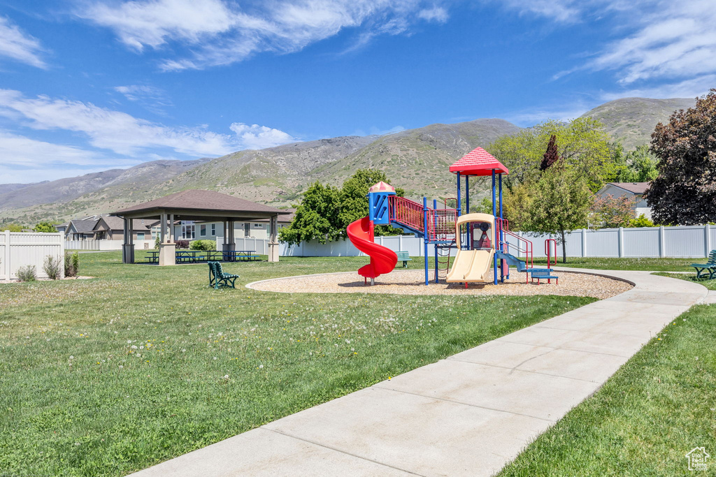 Community playground featuring a lawn, a gazebo, a mountain view, and fence