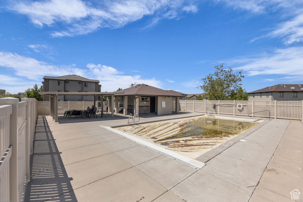 Rear view of property with a patio, outdoor dining space, a community pool, and a fenced backyard