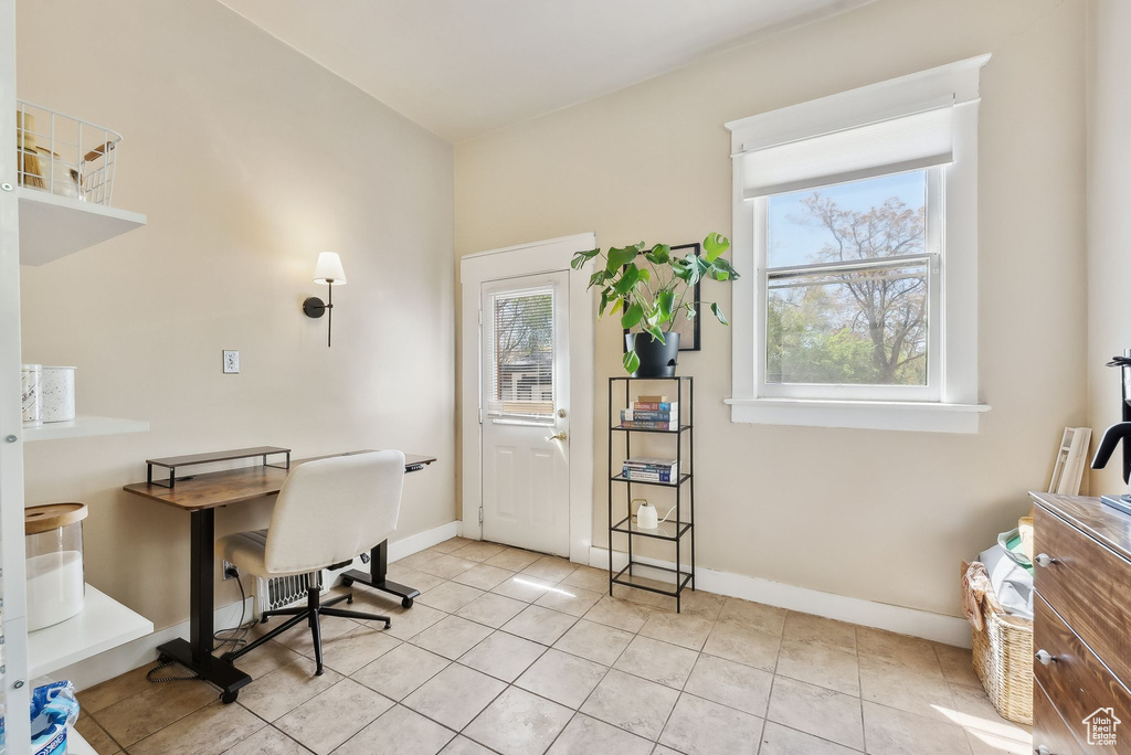 Home office featuring plenty of natural light, baseboards, and light tile patterned floors
