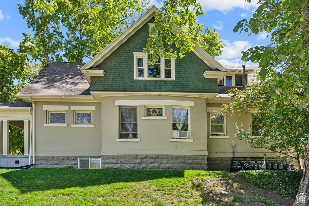 View of side of home featuring a yard, cooling unit, and brick siding