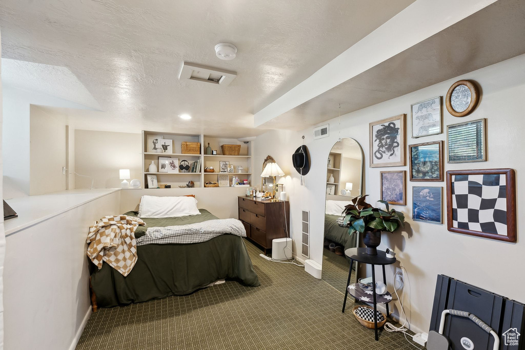 Carpeted bedroom with a textured ceiling, baseboards, and visible vents