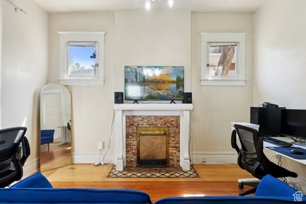 Office space with baseboards, a fireplace with flush hearth, and wood finished floors