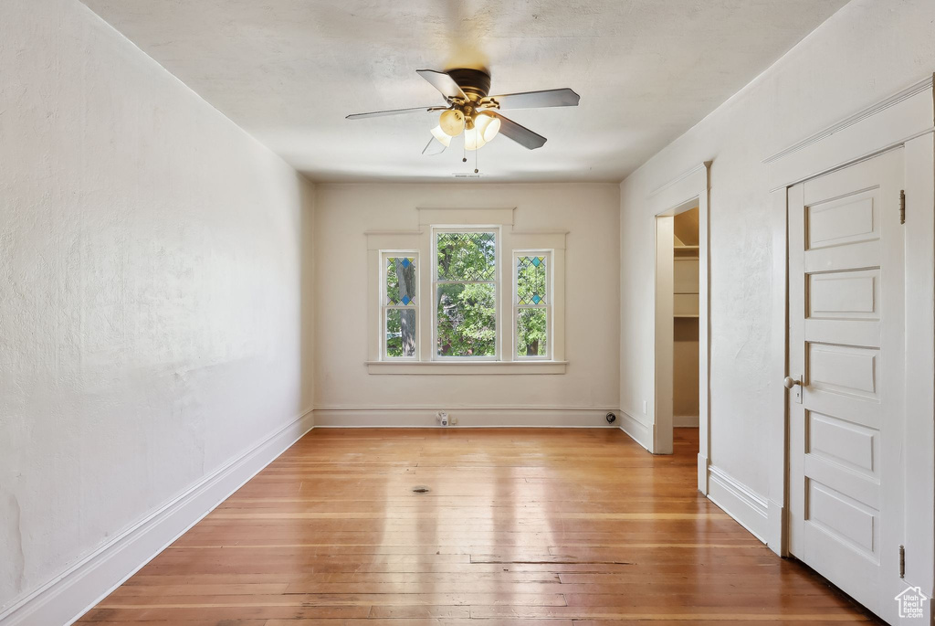 Unfurnished bedroom with baseboards, ceiling fan, a closet, and light wood-type flooring