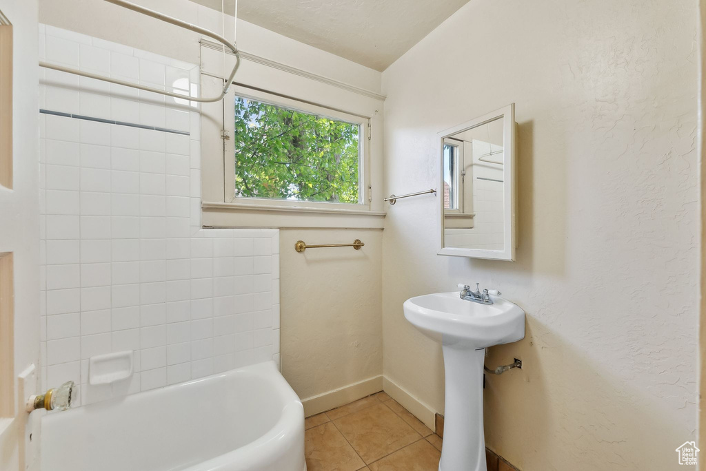 Full bath featuring baseboards and tile patterned floors