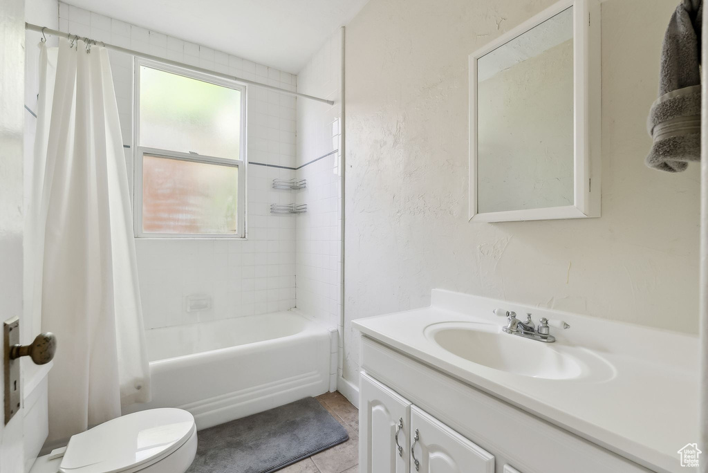 Bathroom with toilet, shower / tub combo, tile patterned flooring, and vanity