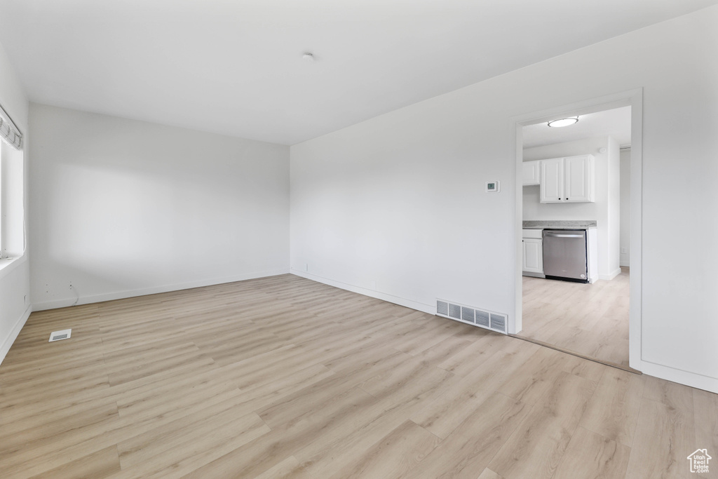 Spare room featuring baseboards, light wood-style flooring, and visible vents