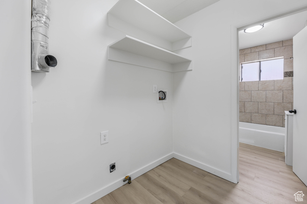 Laundry room featuring laundry area, hookup for an electric dryer, baseboards, hookup for a washing machine, and light wood-style floors