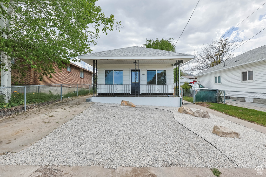 Bungalow featuring driveway, a porch, a gate, and fence