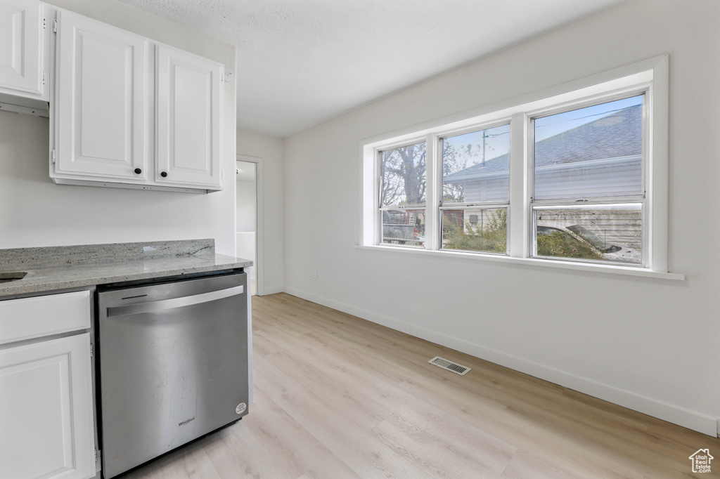 Kitchen featuring light wood-style flooring, white cabinetry, visible vents, baseboards, and dishwasher