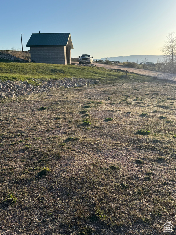 View of yard featuring a rural view, an outbuilding, and a pole building