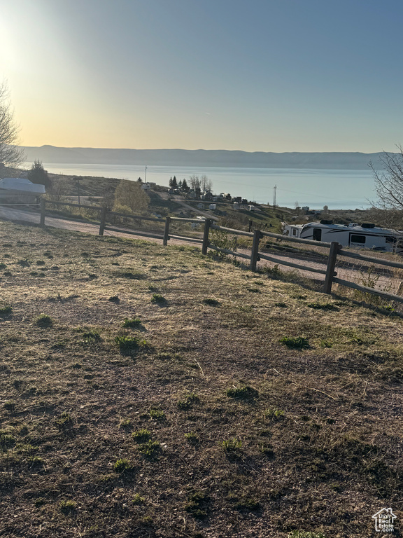 View of yard with a water view and fence