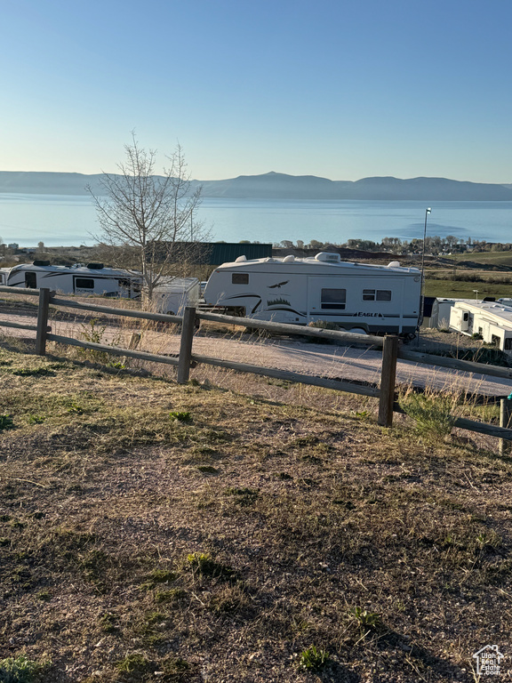 View of yard with fence and a water and mountain view