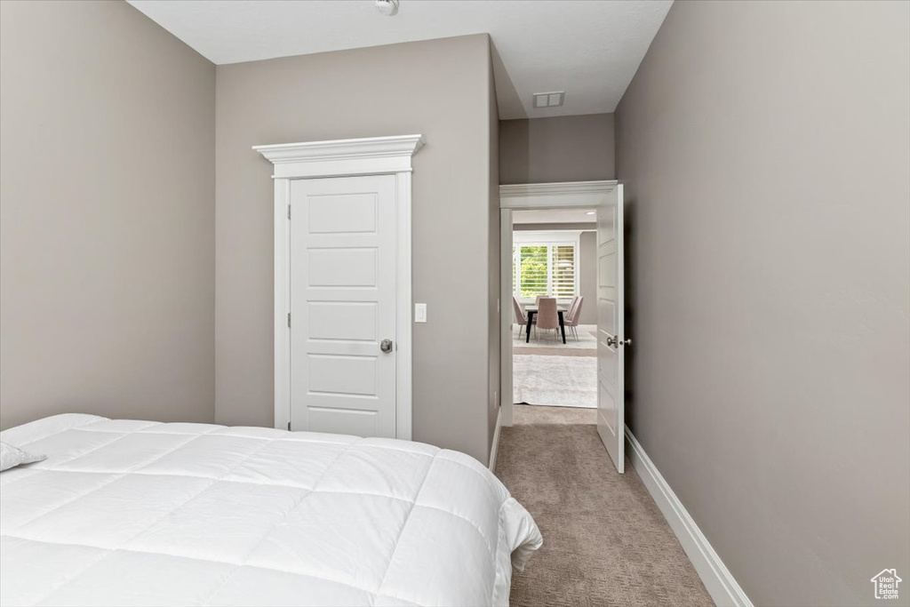 Carpeted bedroom featuring visible vents and baseboards