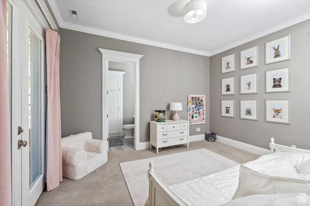 Bedroom with crown molding, ensuite bathroom, light carpet, and visible vents