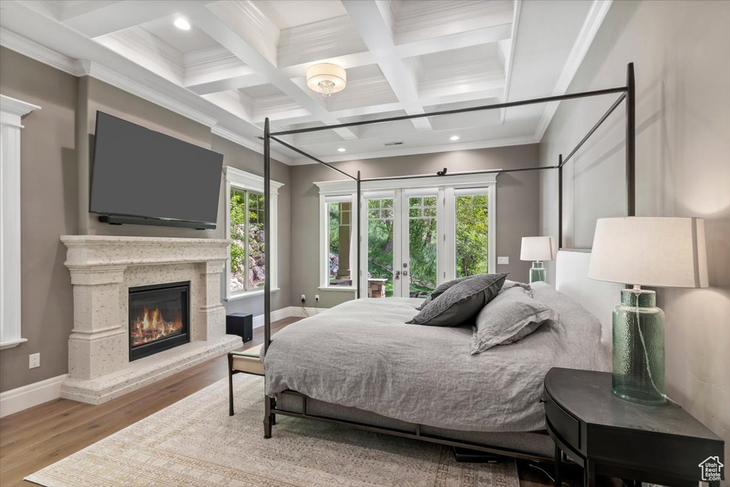 Bedroom featuring french doors, wood finished floors, coffered ceiling, beam ceiling, and baseboards
