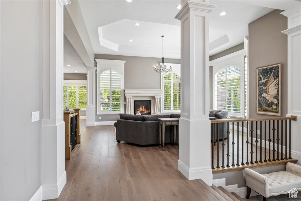 Living room featuring plenty of natural light, baseboards, decorative columns, and hardwood / wood-style floors