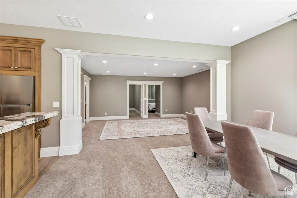 Dining space featuring light carpet, recessed lighting, and ornate columns