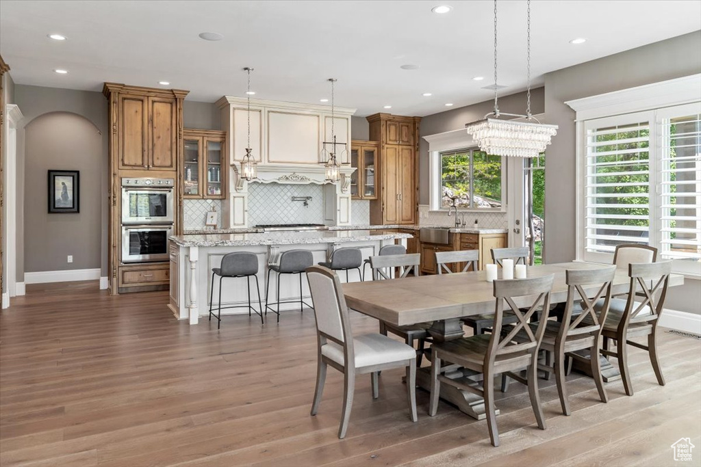 Dining area featuring baseboards, light wood-type flooring, and recessed lighting