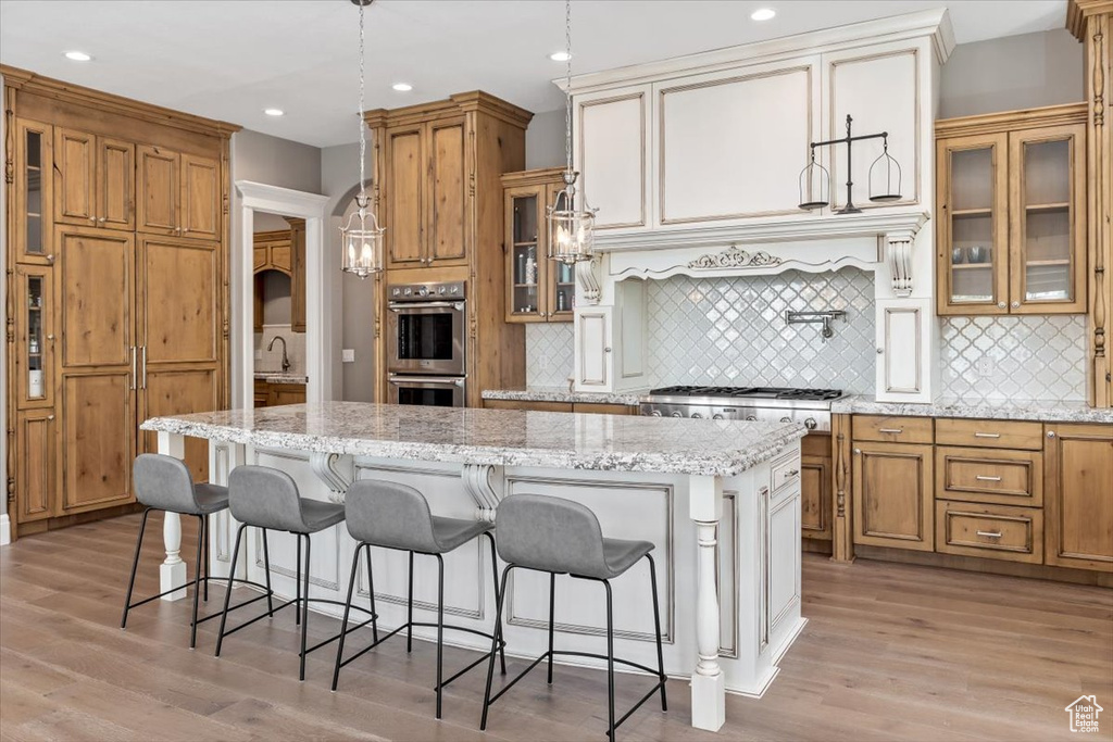 Kitchen with a center island, stainless steel appliances, tasteful backsplash, and brown cabinetry