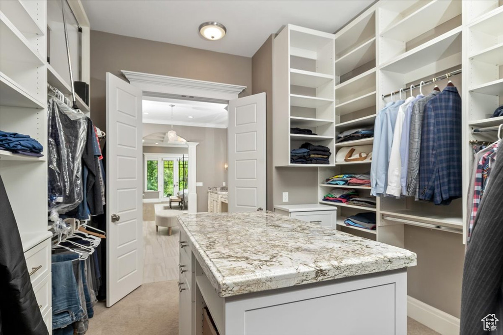 Walk in closet featuring light colored carpet