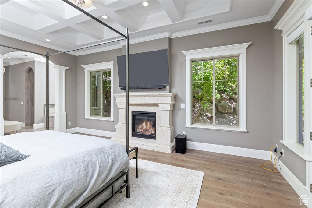 Bedroom featuring multiple windows, decorative columns, and coffered ceiling