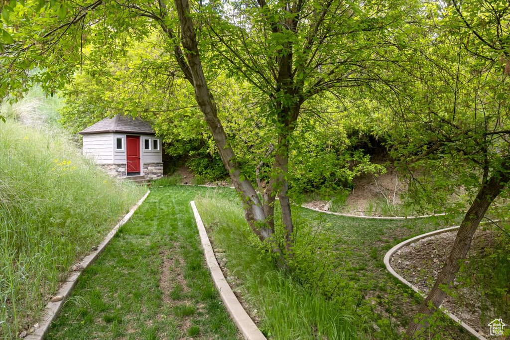 View of yard with an outdoor structure and a view of trees