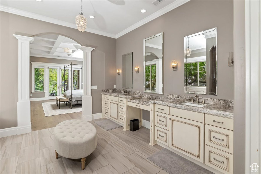Full bath with ornate columns, crown molding, ensuite bathroom, baseboards, and vanity