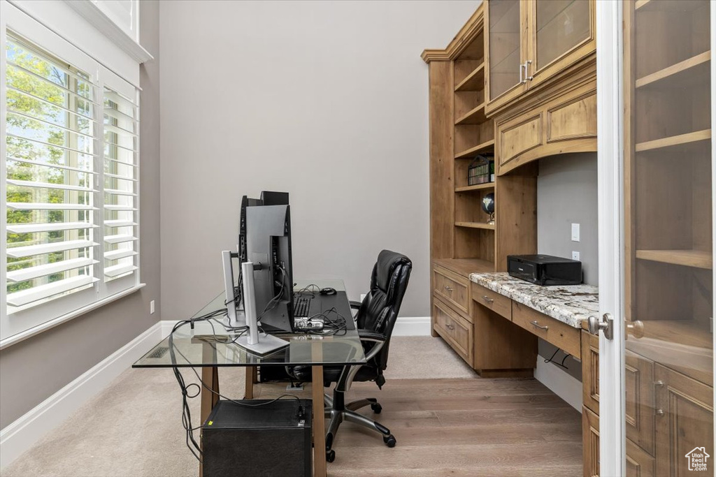 Office area with light wood-style flooring, a wealth of natural light, and baseboards