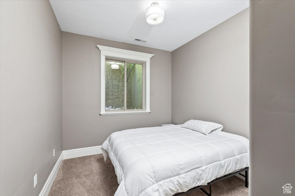 Bedroom featuring baseboards, visible vents, and carpet floors