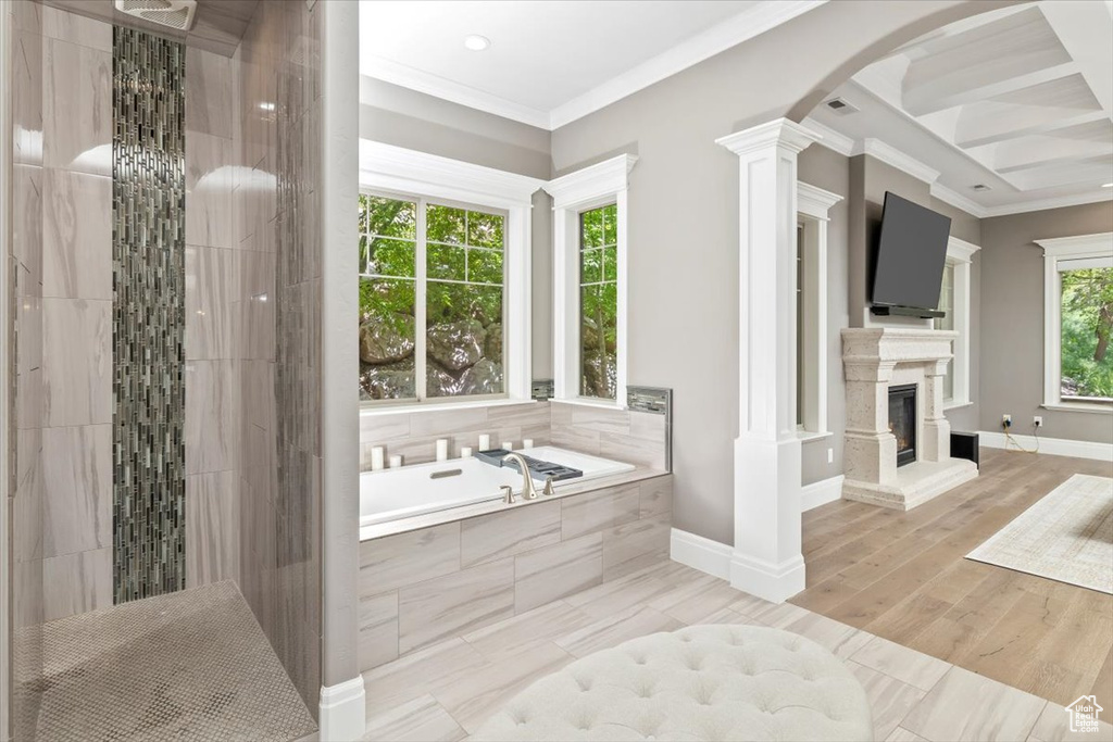 Full bathroom with a bath, crown molding, visible vents, baseboards, and a glass covered fireplace