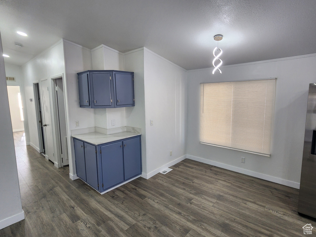 Kitchen with baseboards, light countertops, dark wood-style floors, and blue cabinetry