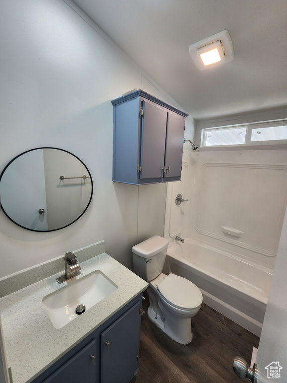 Full bath with toilet, wood finished floors, vanity, and shower / bath combination