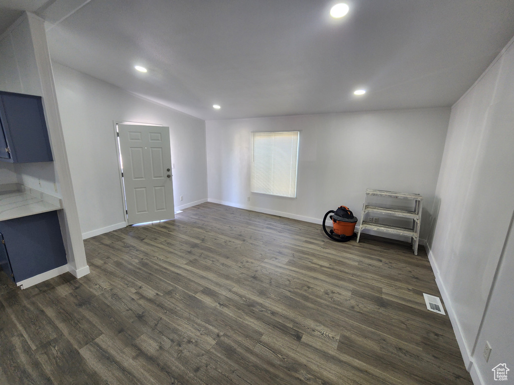Interior space featuring baseboards, dark wood-style flooring, visible vents, and recessed lighting