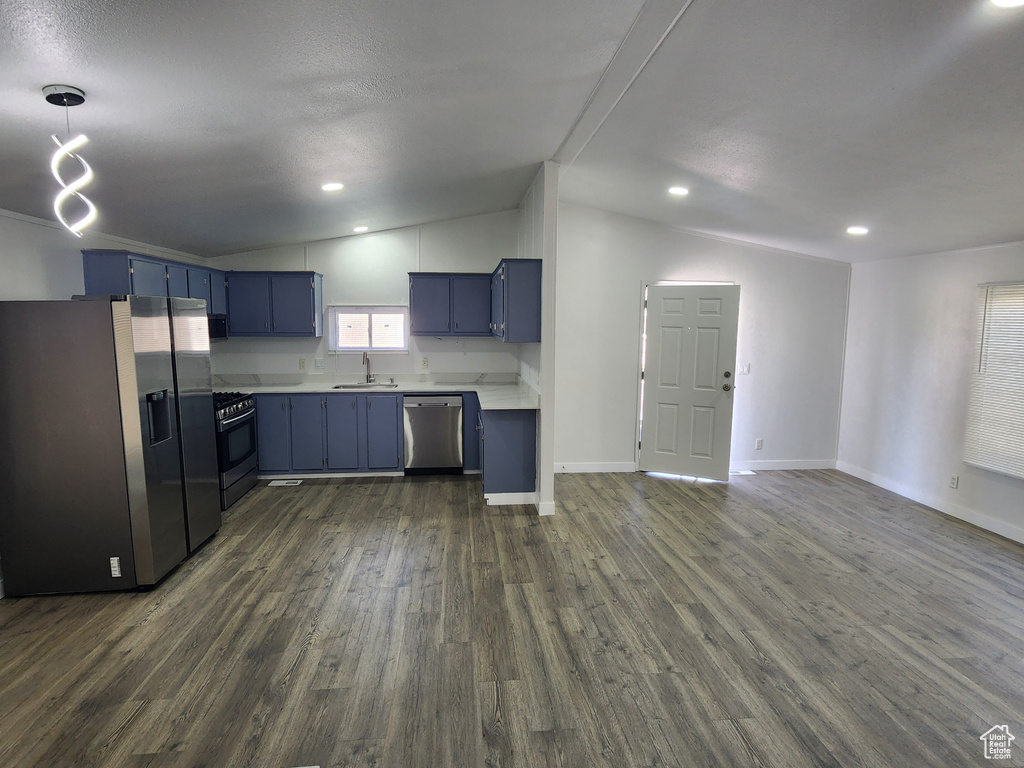 Kitchen with a sink, stainless steel appliances, light countertops, vaulted ceiling, and blue cabinets