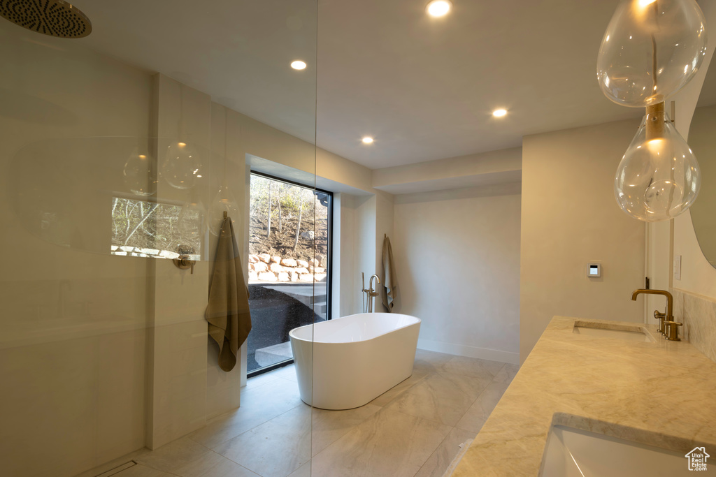 Bathroom with a sink, a freestanding bath, double vanity, and recessed lighting