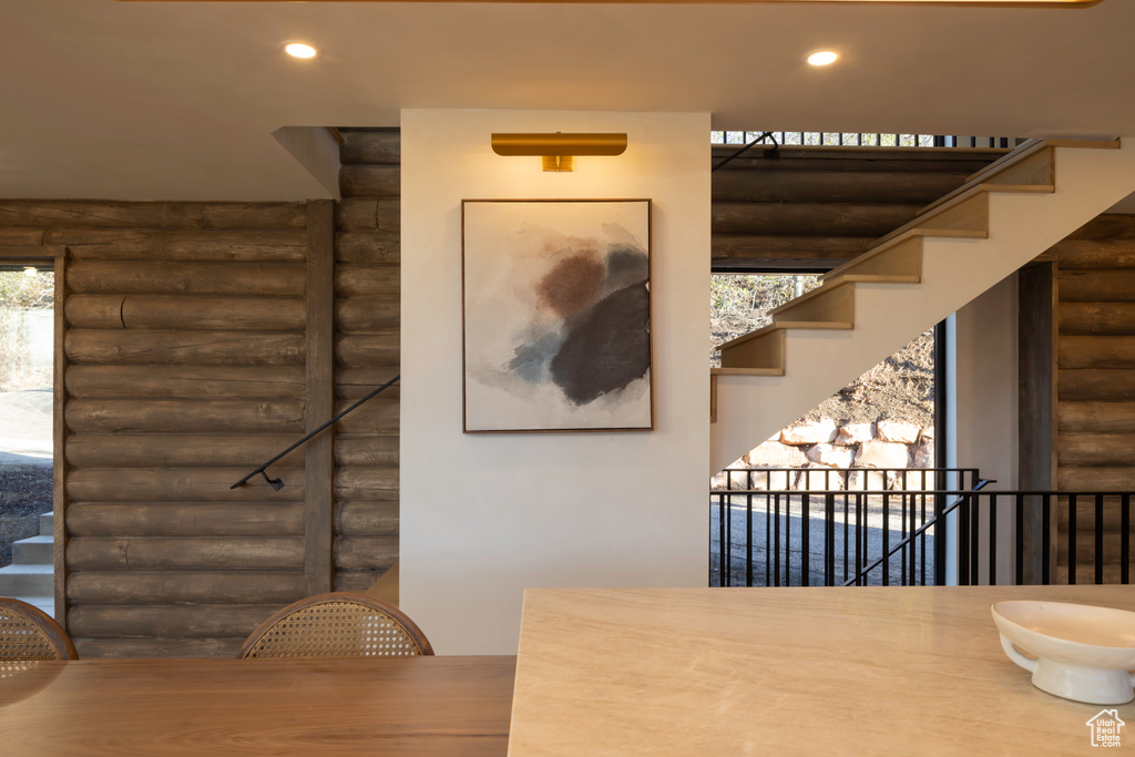 Unfurnished dining area featuring stairs, rustic walls, and recessed lighting