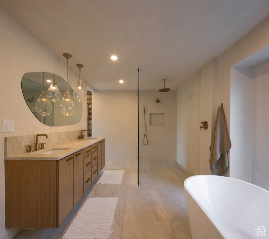 Full bathroom featuring double vanity, a freestanding bath, a walk in shower, and a sink