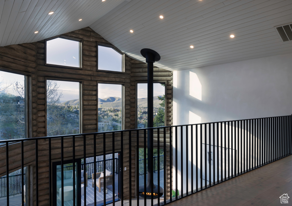 Corridor with recessed lighting, rustic walls, high vaulted ceiling, and wood ceiling