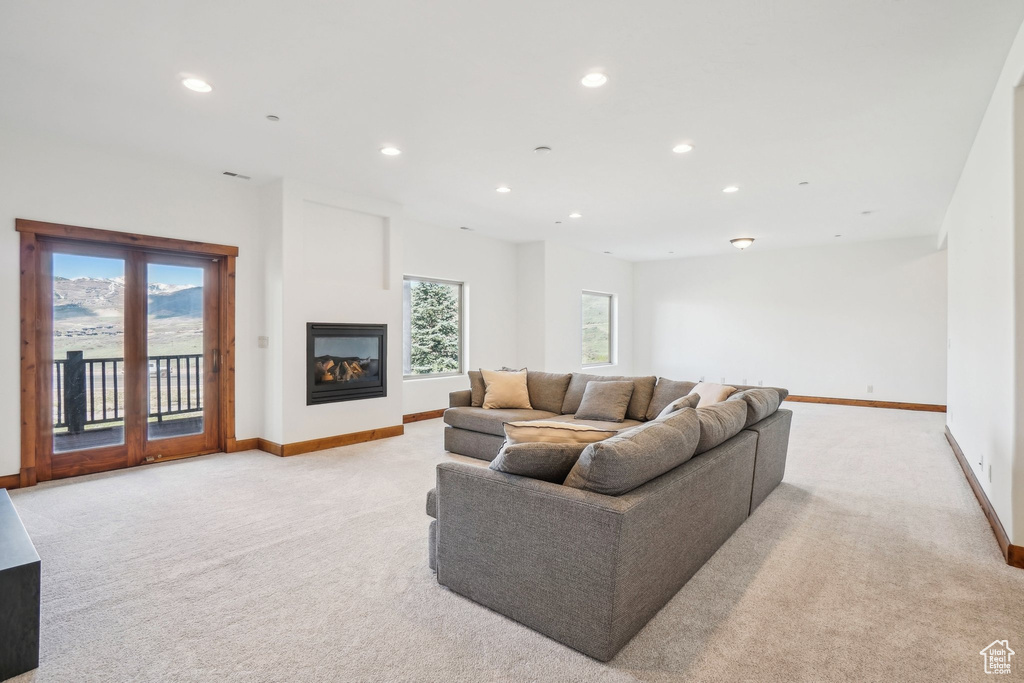 Living room with baseboards, a healthy amount of sunlight, recessed lighting, and light colored carpet
