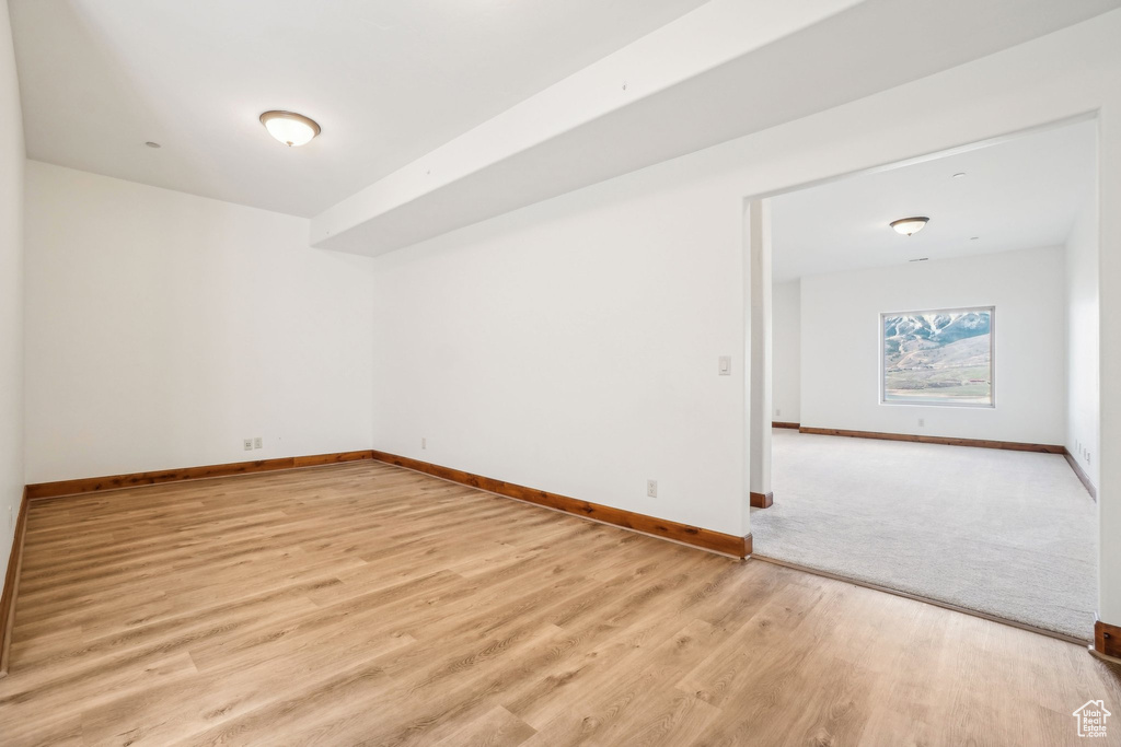 Empty room featuring baseboards and light wood finished floors