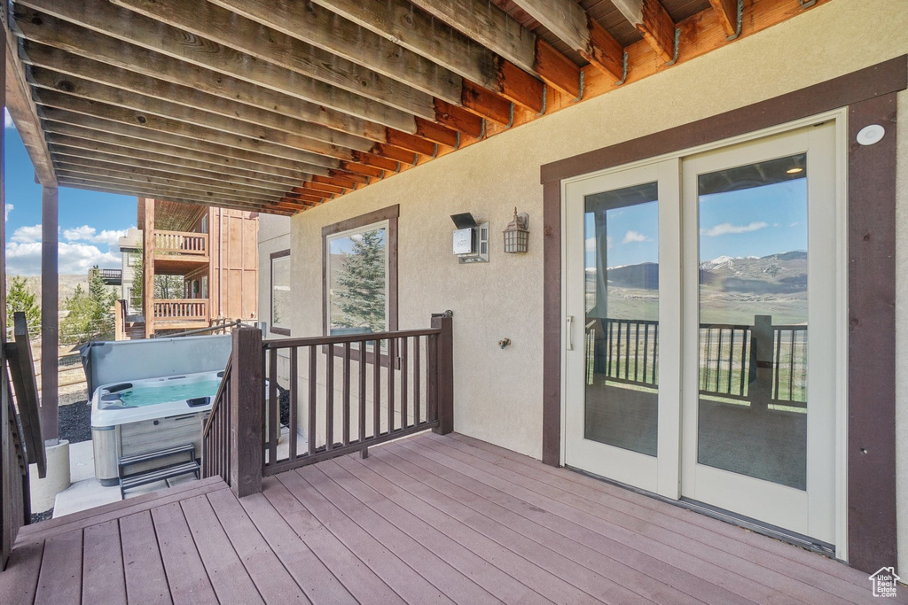 Wooden terrace with a mountain view and a hot tub