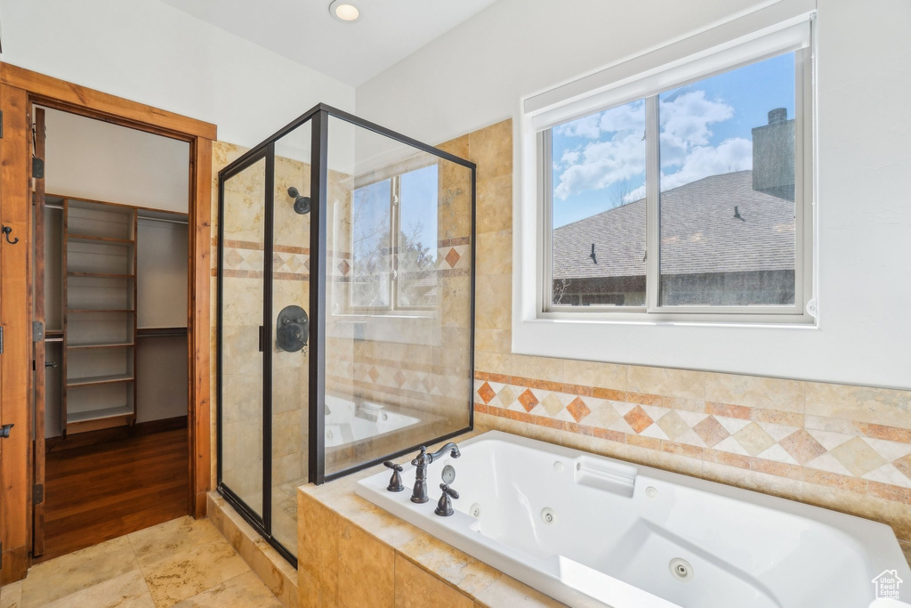 Full bathroom with a jetted tub and a stall shower
