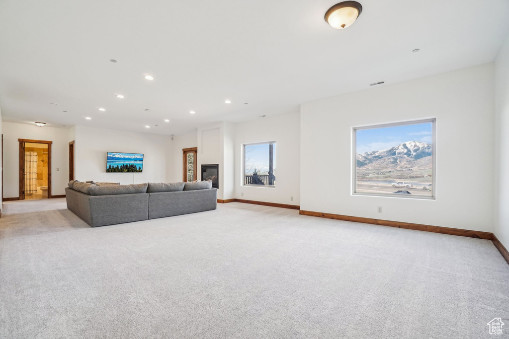 Living room featuring light colored carpet, baseboards, and recessed lighting
