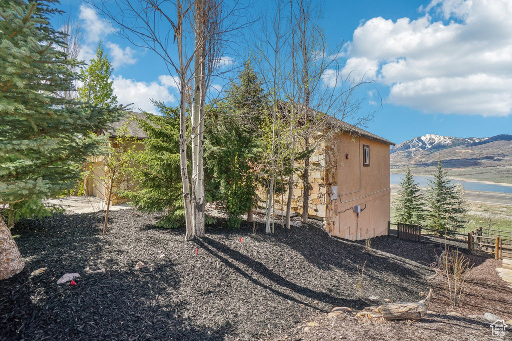 View of side of property featuring fence and a water and mountain view