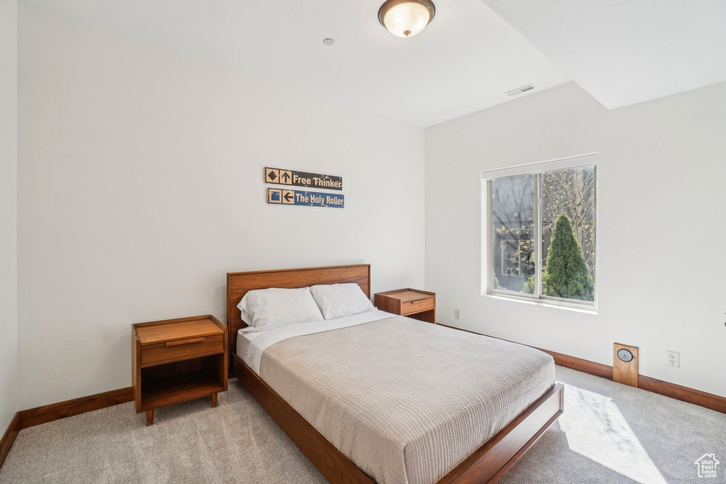 Bedroom with baseboards, visible vents, and carpet