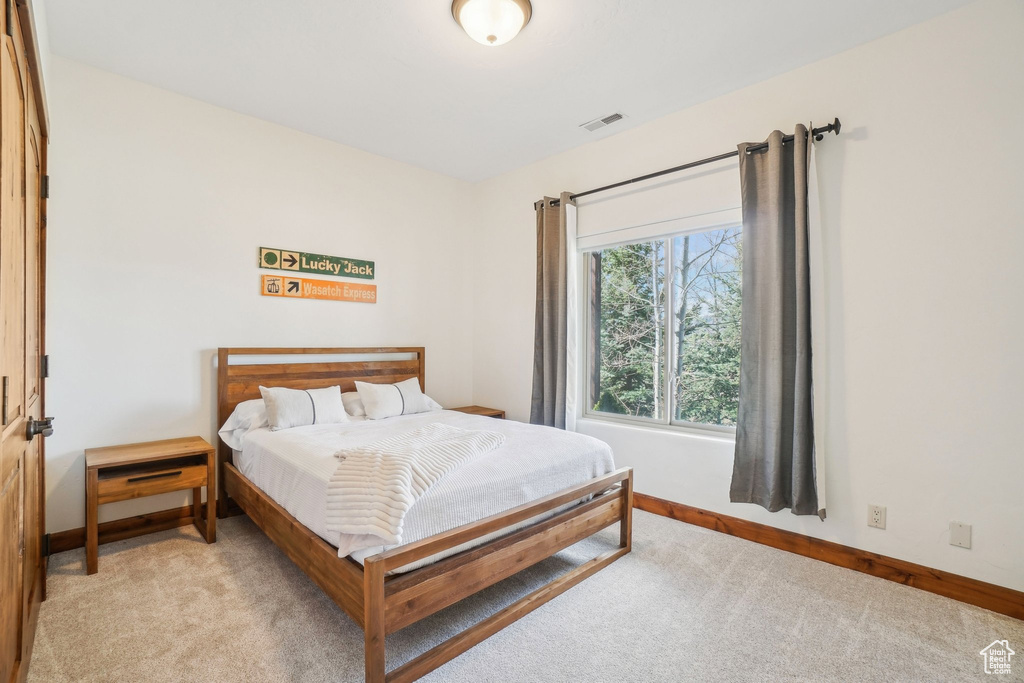 Bedroom with baseboards, light carpet, and visible vents
